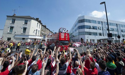 Arsenal players wave to fans from the bus